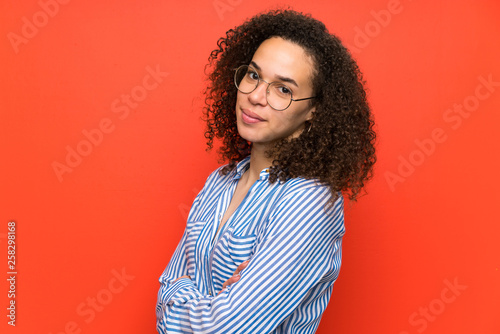 Dominican woman over red wall laughing