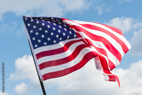 Fototapeta Naklejka Na Ścianę i Meble -  low angle view of stars and stripes on american flag against blue sky
