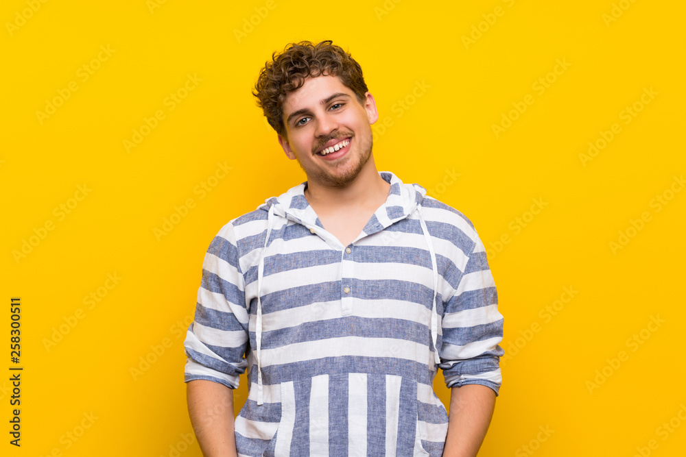 Blonde man over yellow wall With happy expression Blonde man over yellow wall With happy expression