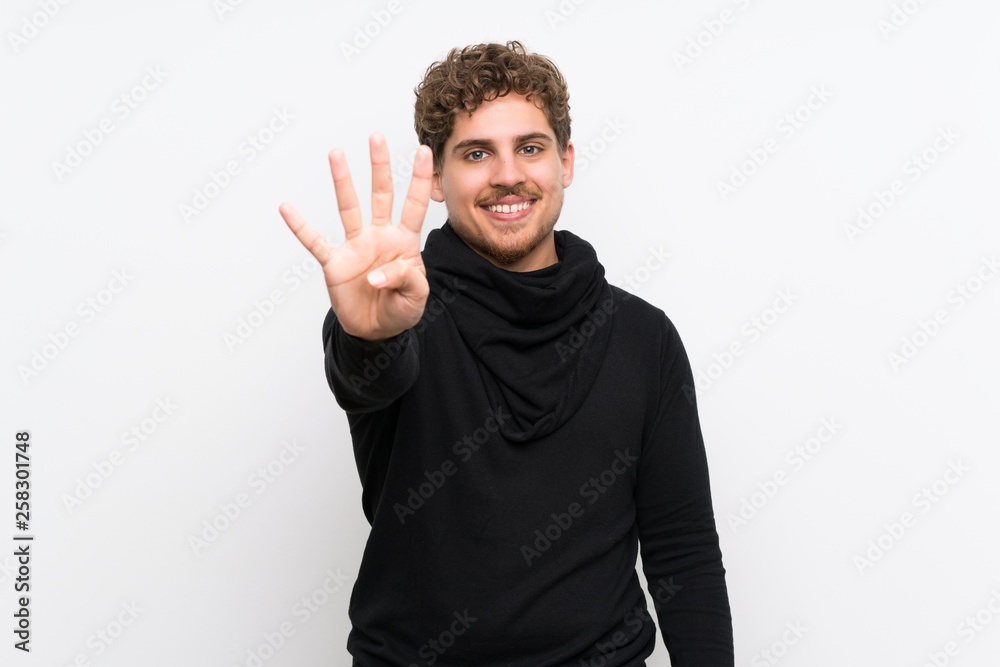 Blonde man over isolated white wall happy and counting four with fingers Blonde man over isolated white wall happy and counting four with fingers