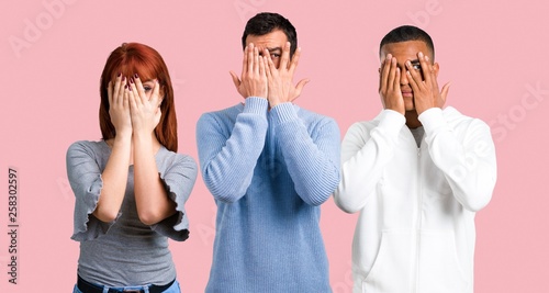 Group of three friends covering eyes by hands