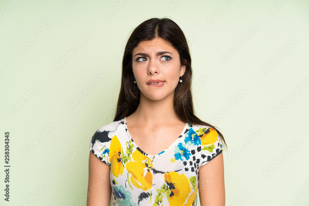 Teenager girl with floral dress having doubts and with confuse face expression Teenager girl with floral dress having doubts and with confuse face expression