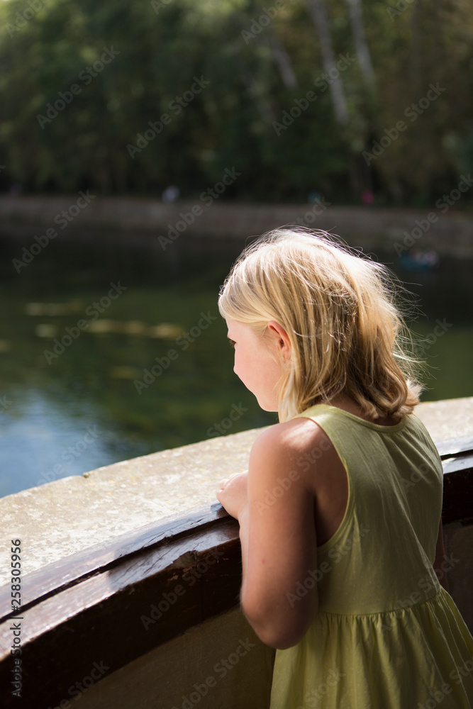 girl looks at the river from balcony