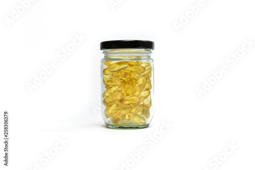 Fish oil capsules in jar glass isolated on white background. Omega 3. Vitamin E. Supplement food background.