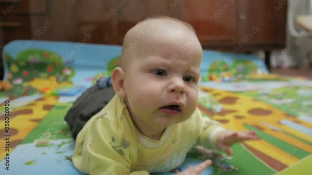 A little baby on all fours playing on the floor. close-up A little baby on all fours playing on the floor. close-up