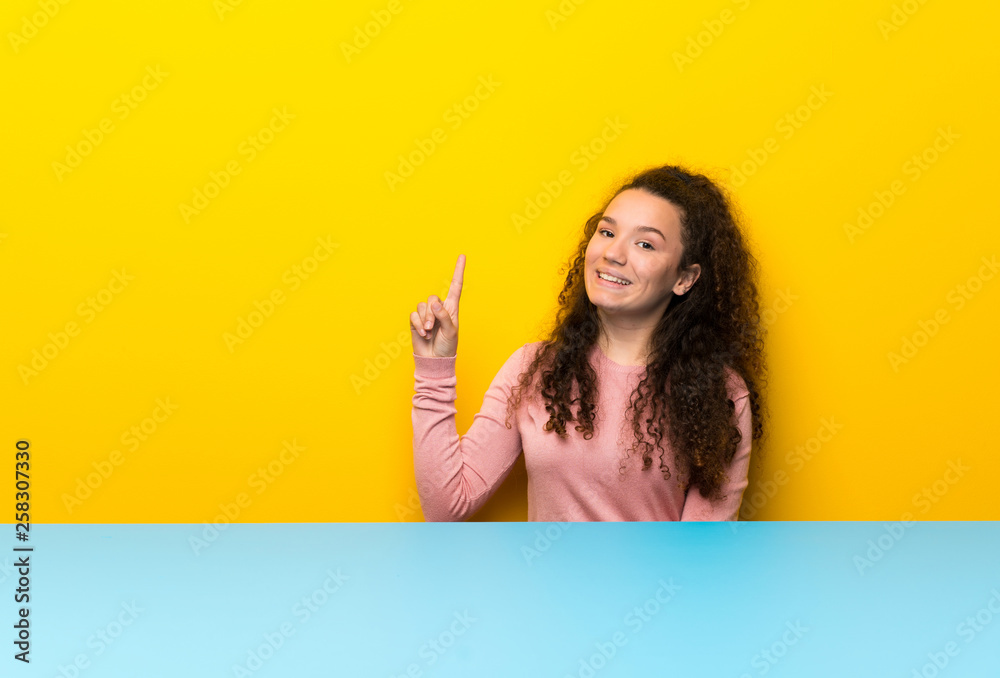 Teenager girl showing and lifting a finger in sign of the best Teenager girl showing and lifting a finger in sign of the best