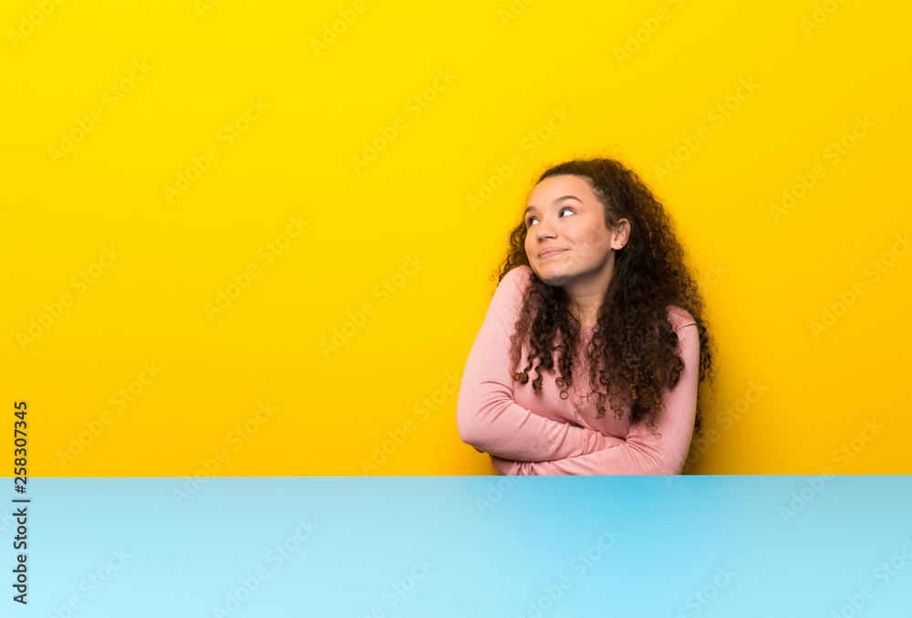 Teenager girl making doubts gesture while lifting the shoulders Teenager girl making doubts gesture while lifting the shoulders