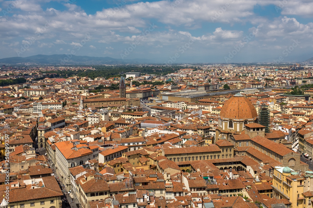 A sweeping view of the skyline and rooftops of Florence from the top of Giotto's bell tower, next to the cathedral, looking out towards the main railway station.
