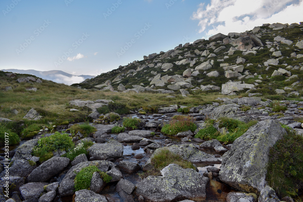 A stream surrounded by rocks near the lake Les Abelletes, in the town Pas de la Casa, Andorra A stream surrounded by rocks near the lake Les Abelletes, in the town Pas de la Casa, Andorra