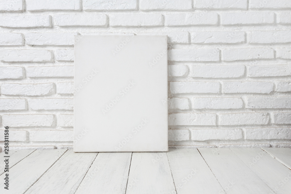 Empty white canvas frame on a wooden table Empty white canvas frame on a wooden table