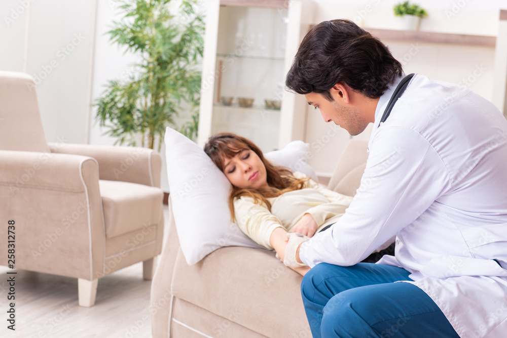 Young handsome doctor visiting female patient at home Young handsome doctor visiting female patient at home