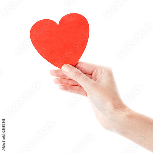 Female hand isolated on white background. White woman's hand showing symbols and gestures. Red wooden heart in hand. Love