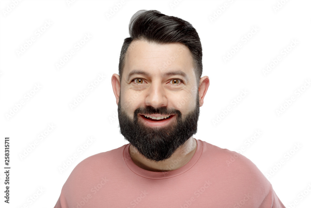 Obraz premium A cute young bearded man in pink shirt shows emotionally happy