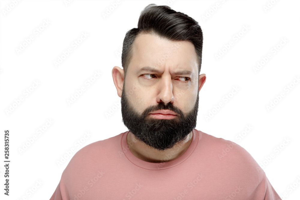 Fototapeta premium A cute young bearded man in pink shirt shows emotionally happy