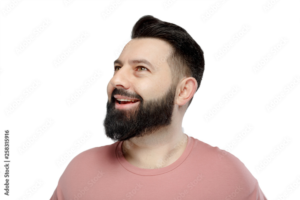 Obraz premium A cute young bearded man in pink shirt shows emotionally happy