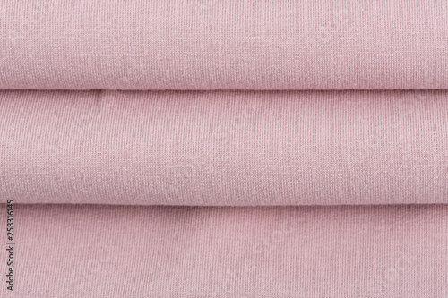 Pink cotton textile - close up of fabric texture. Cotton Fabric Texture. Top View of Cloth Textile Surface. Pink Clothing Background. Text Space. Abstract background and texture for designers.