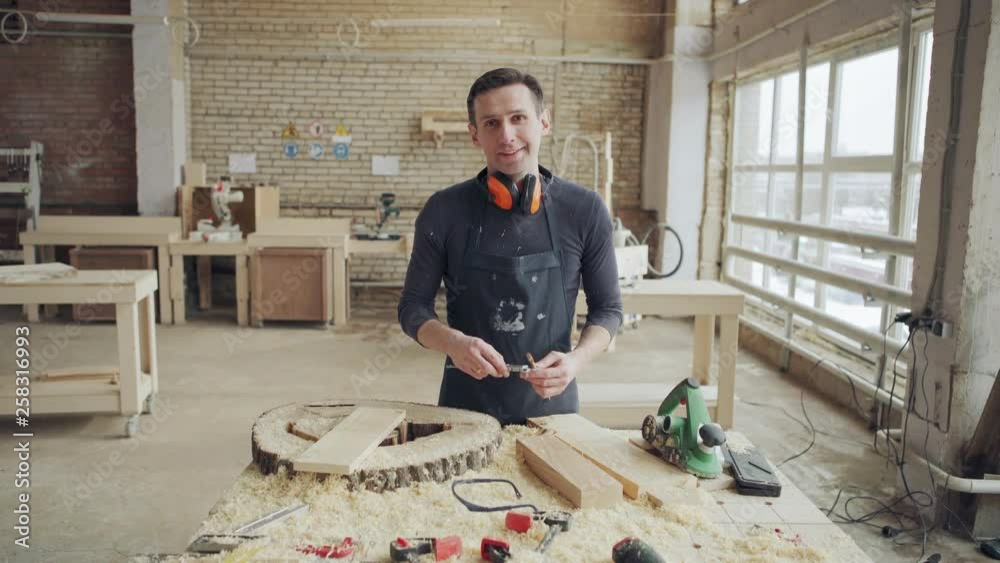 Professional furniture maker standing at workbench with vernier caliper