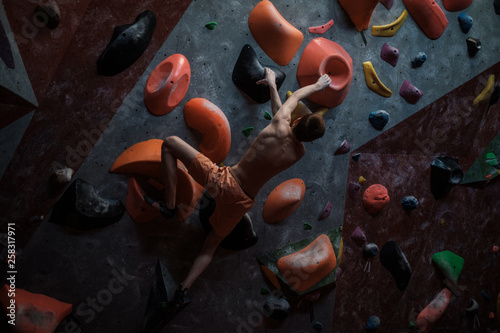 Athletic man practicing in a bouldering gym