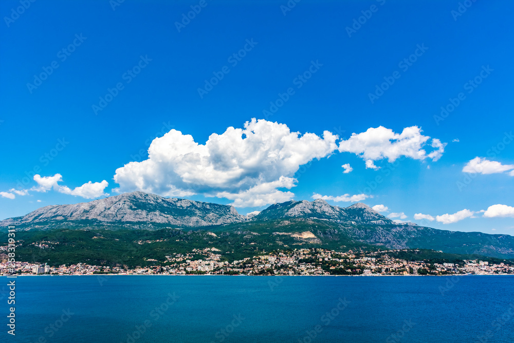 Sea town with mountains clouds and clear sky