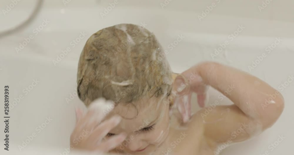 Attractive three years old girl takes a bath. Cleaning and washing hair Attractive three years old girl takes a bath. Cleaning and washing hair