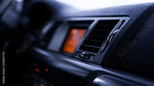 Buttons of radio, dashboard, climate control in car close up - black and orange © brillianata