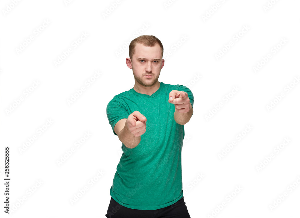 A funny young man in a green shirt shows A funny young man in a green shirt shows