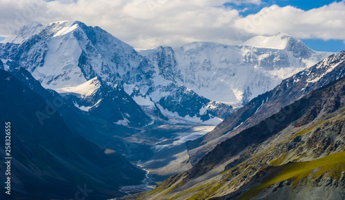 Fotografia green mountain valley and a snowbound ridge