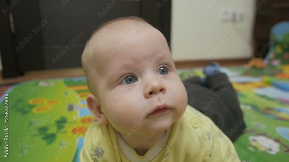 A little baby on all fours playing on the floor. Children's joy, smile. A little baby on all fours playing on the floor. Children's joy, smile.