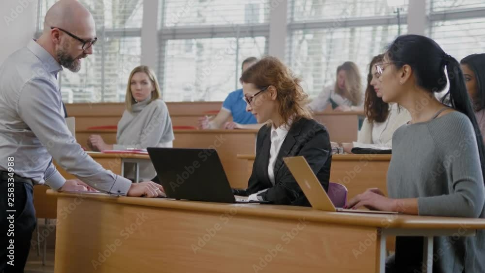 Lecturer and multinational group of students in an auditorium Lecturer and multinational group of students in an auditorium