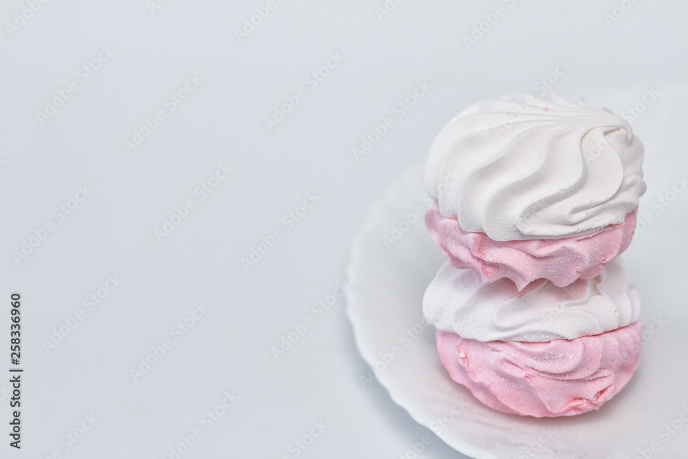 White-pink zephyr on a white plate on a white background. White-pink zephyr on a white plate on a white background.