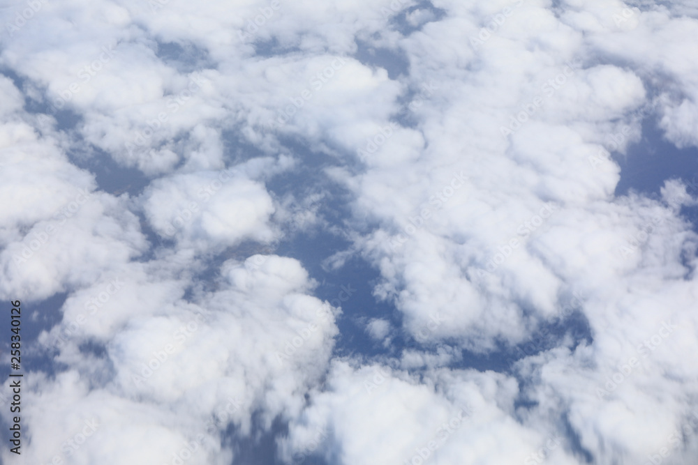 white clouds in a blue dramatic sky with a view from the plane
