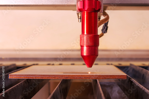 Obraz na plátně Laser engraver working and engraving flat wooden board