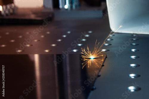 Closeup laser engraver working and engraving flat metal surface