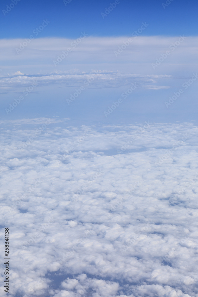 white clouds in a blue dramatic sky with a view from the plane