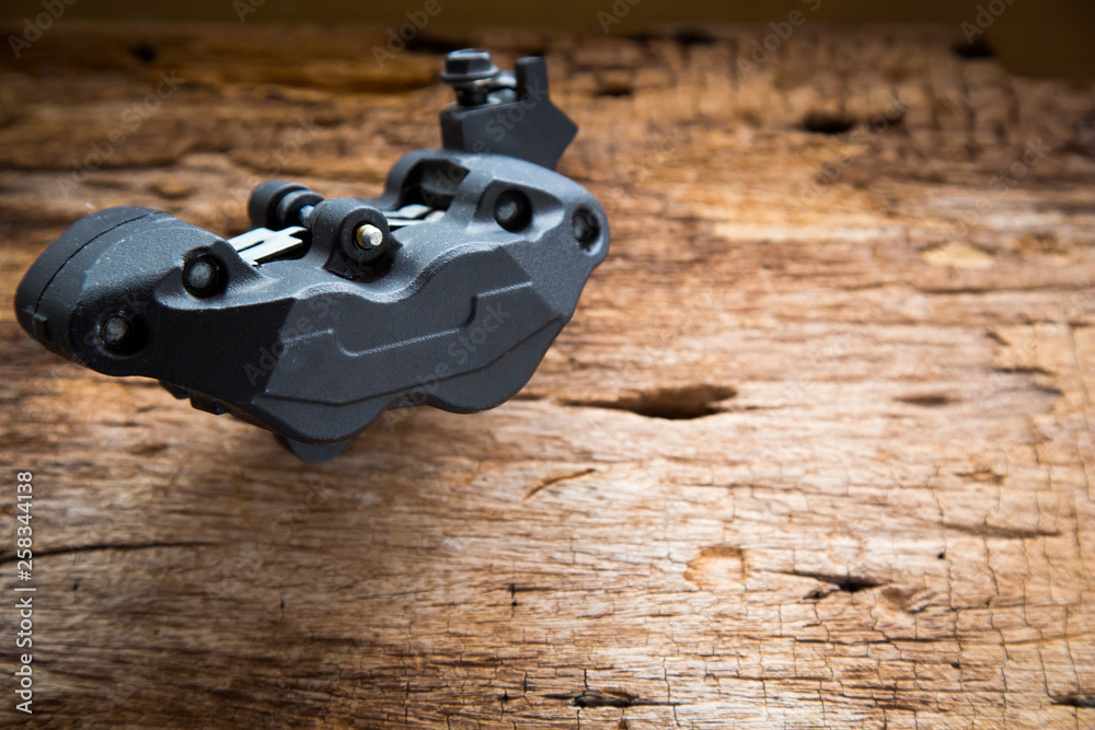 Obraz premium Close up photo of Caliper brake system for big bike on old wood background