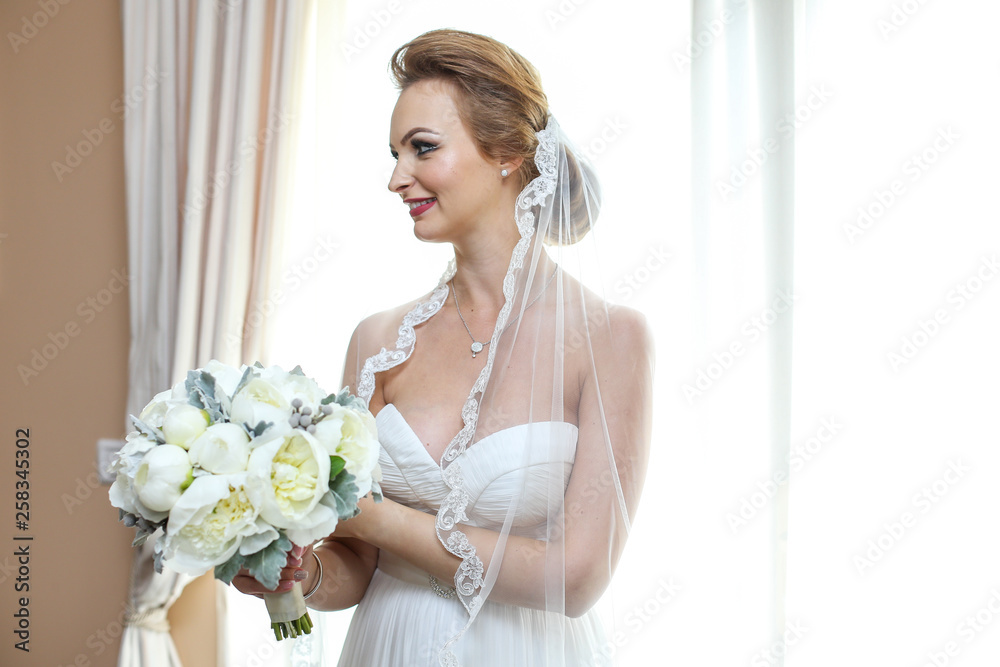 Joyful bride holding beautiful bridal bouquet