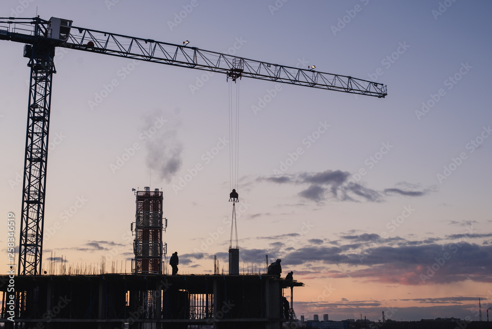 Construction crane on the construction site. Under construction concrete building.