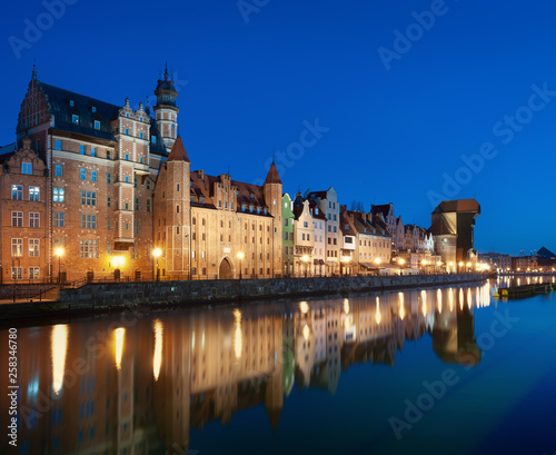Old town in Gdansk, Poland at night. Riverside with the famous Crane and city reflections in the Motlava river. High resolution panorama.