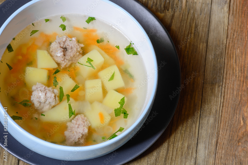 Vegetable soup with chicken cutlets and pieaces of homemade bread.Side view with copy space. Vegetable soup with chicken cutlets and pieaces of homemade bread.Side view with copy space.