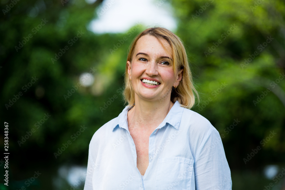 Portrait of older woman smiling natural light in park Portrait of older woman smiling natural light in park