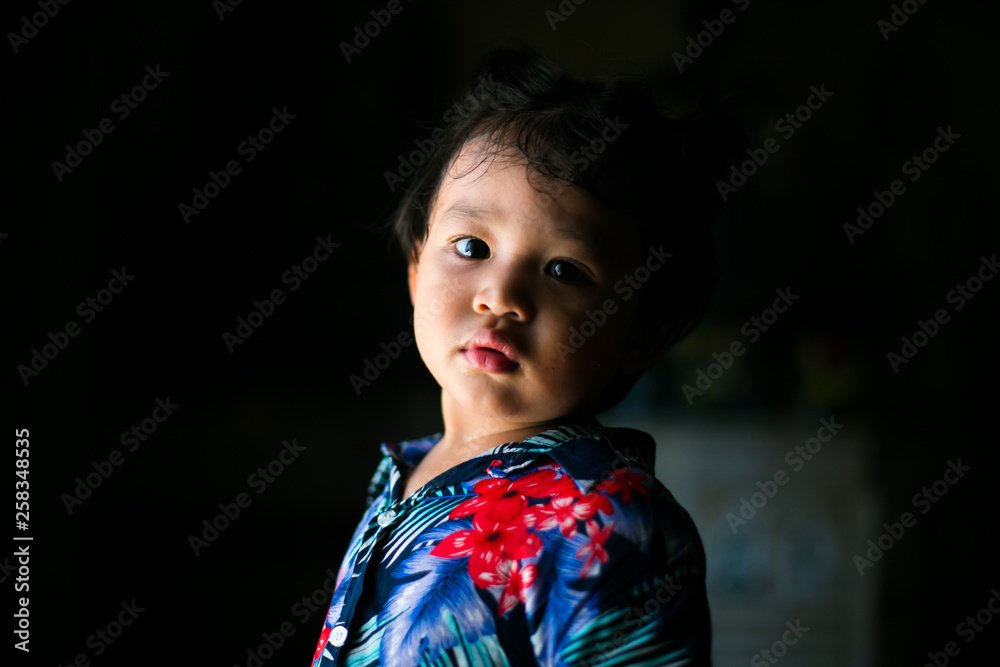 Sad Asian little boy on dark background