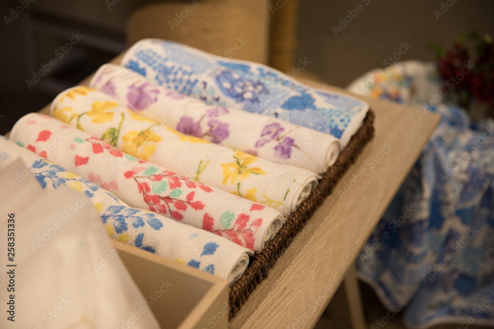 The rolled up towels are on the shelf The rolled up towels are on the shelf