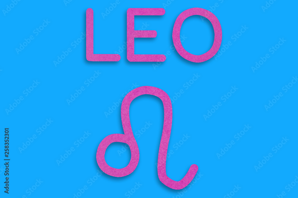 Symbol of astrological sign and word leo cut out of purple paper on blue table. Top view. Horoscope concept Symbol of astrological sign and word leo cut out of purple paper on blue table. Top view. Horoscope concept