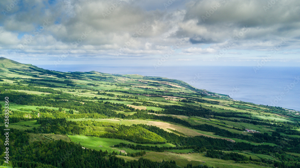 Aerial view on scenic landscape of volcano and green fields around it. Special shape of ground. Top view from drone. Azores islands, Sao Miguel, Portugal. Aerial view on scenic landscape of volcano and green fields around it. Special shape of ground. Top view from drone. Azores islands, Sao Miguel, Portugal.