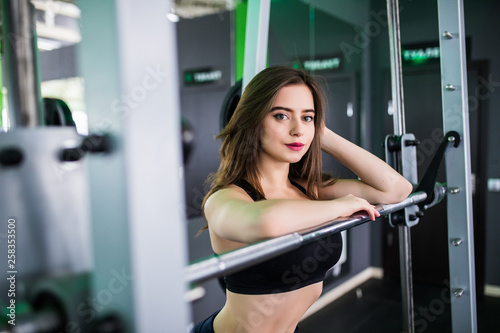 Young fitness woman before lifting weight in gym