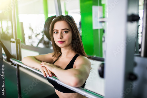 Young fitness woman before lifting weight in gym