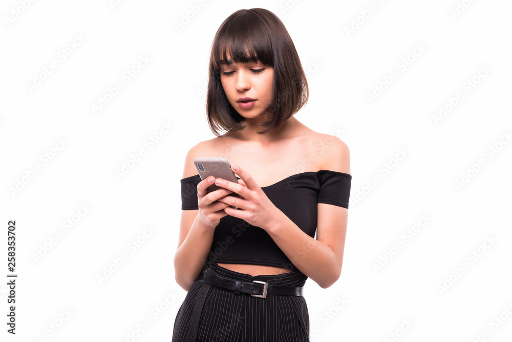 Portrait of a smiling casual woman holding smartphone over white background Portrait of a smiling casual woman holding smartphone over white background