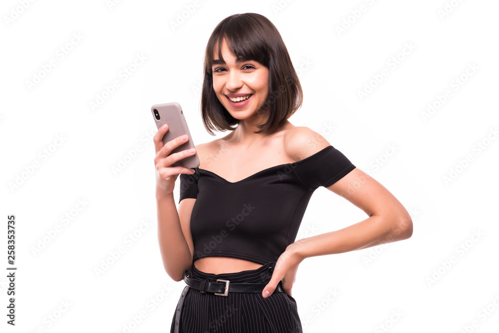 Portrait of pretty glad girl typing sms to her friend isolated white background Portrait of pretty glad girl typing sms to her friend isolated white background