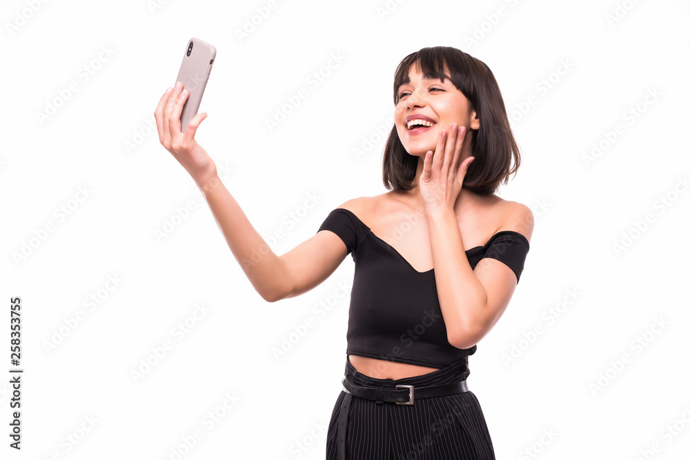 Pretty young happy woman making selfie on smartphone isolated on white background Pretty young happy woman making selfie on smartphone isolated on white background