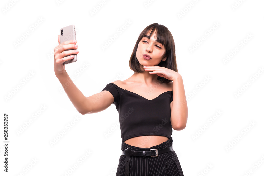 Pretty young happy woman making selfie on smartphone isolated on white background Pretty young happy woman making selfie on smartphone isolated on white background